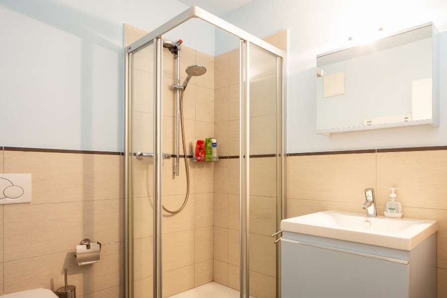 Salle de bain moderne avec une vasque originale blanche intégrée sur un meuble bleu.